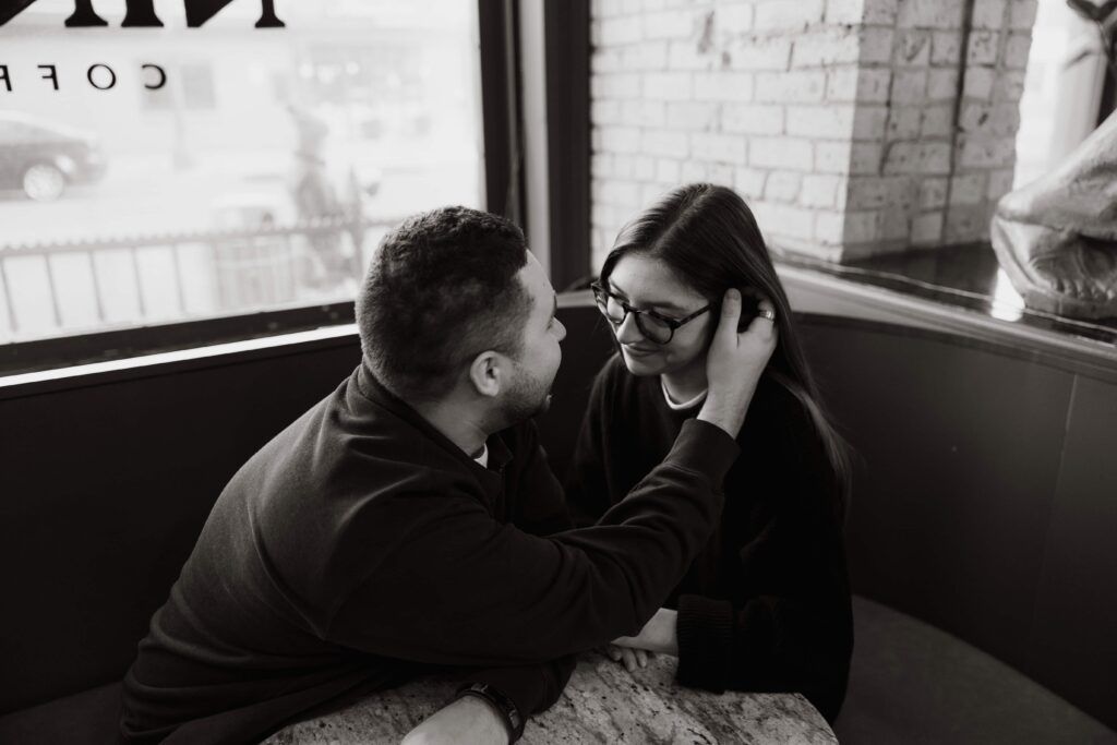 Man brushes the hair out of his fiance's face at Nina's cafe in St. Paul, Minnesota.