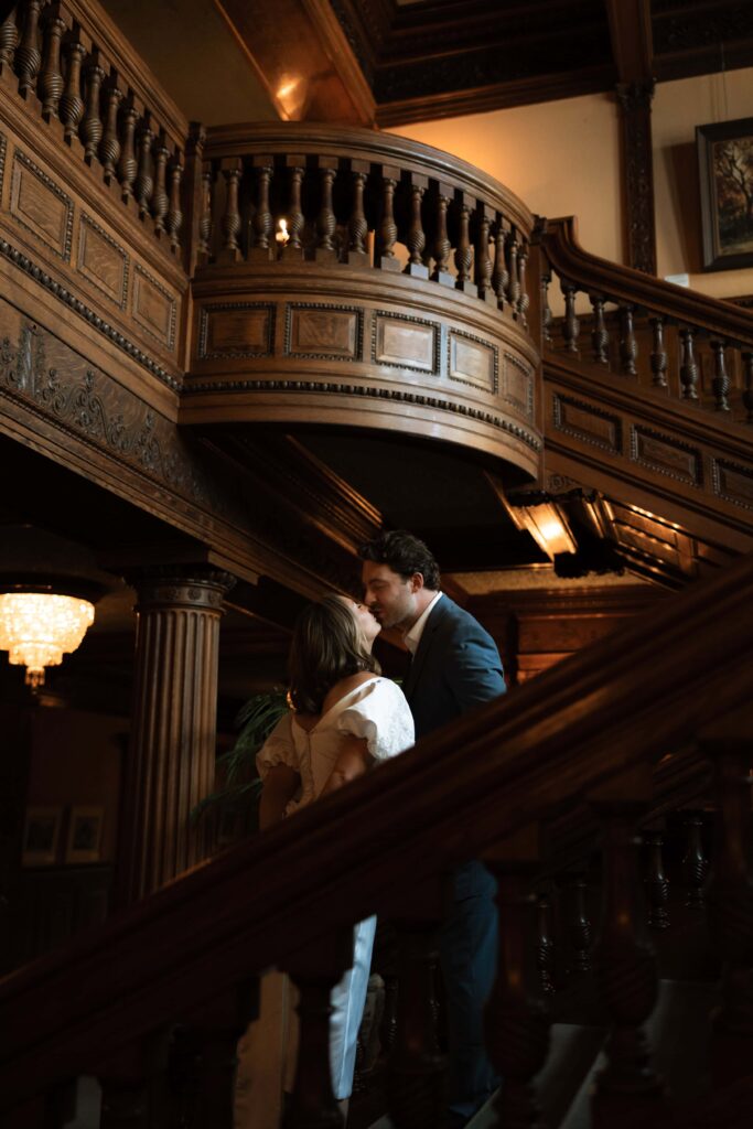 Couple kiss on the staircase at James J. Hill House.