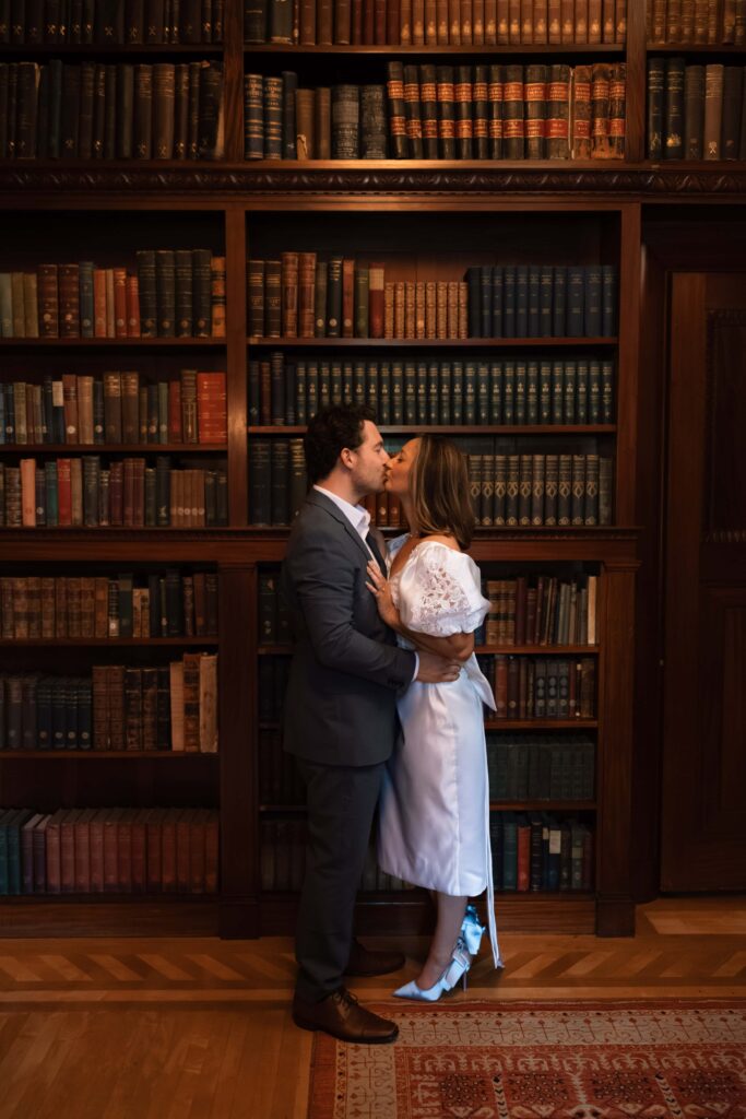 Romantic couple kiss in a historic library.