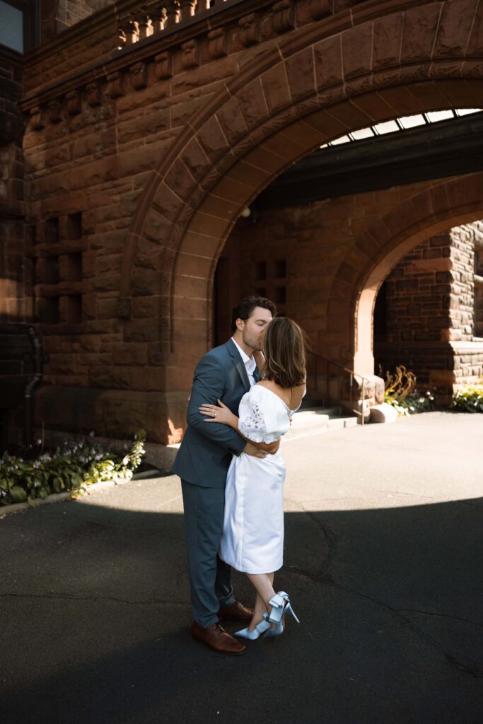 Engaged couple kiss in front of James J. Hill House in St. Paul, Minnesota.