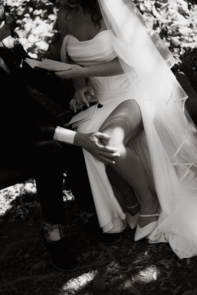 Groom places his hand on the bride's leg as she reads her wedding vows.
