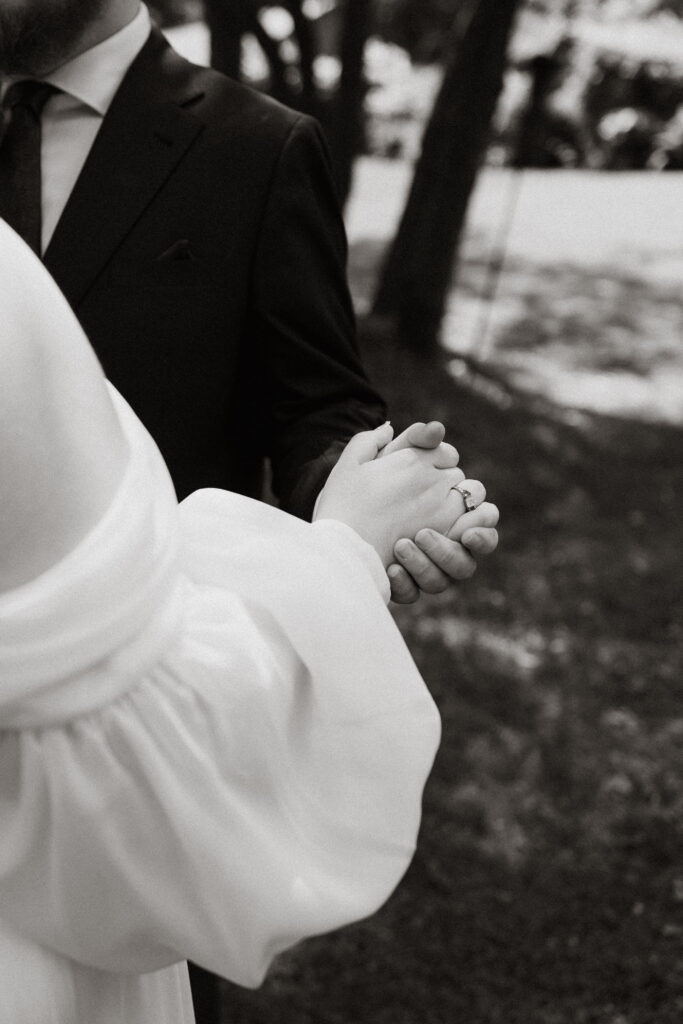 Bride and groom hold hands as they dance.