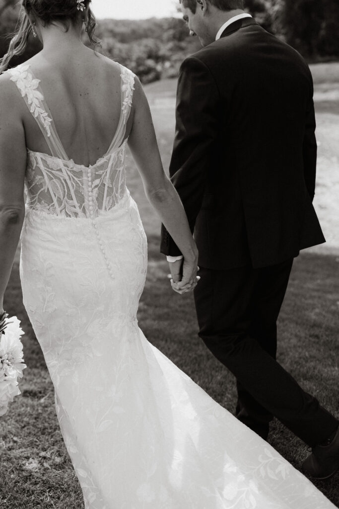 Bride and groom walking holding hands at European Inspired Venue.