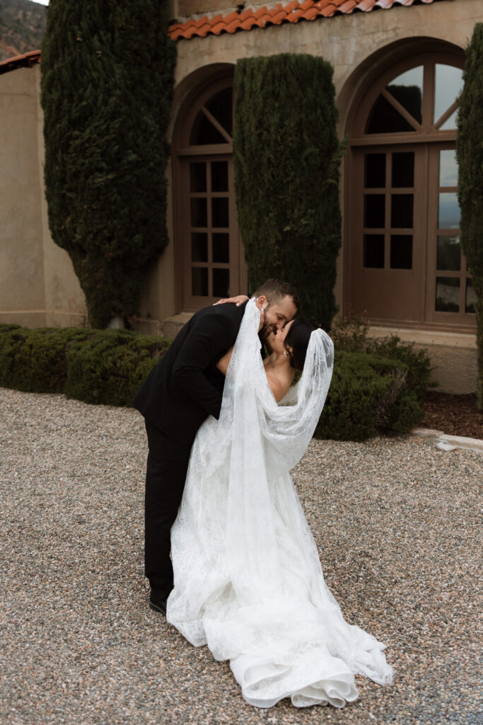 Bride and groom kiss at The Little Daisy in Jerome, Arizona. This editorial and lacy styled wedding was beautifully styled for their destination wedding.