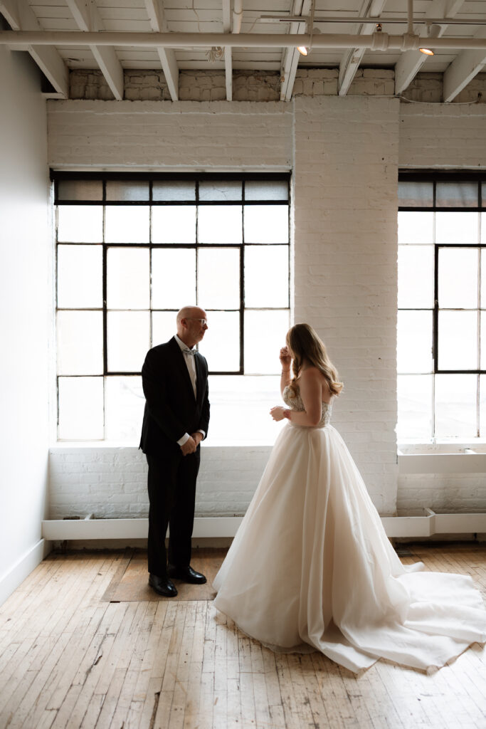 Father of the bride and bride have an emotional moment before the ceremony starts at The Neu Neu in Minneapolis, Minnesota.