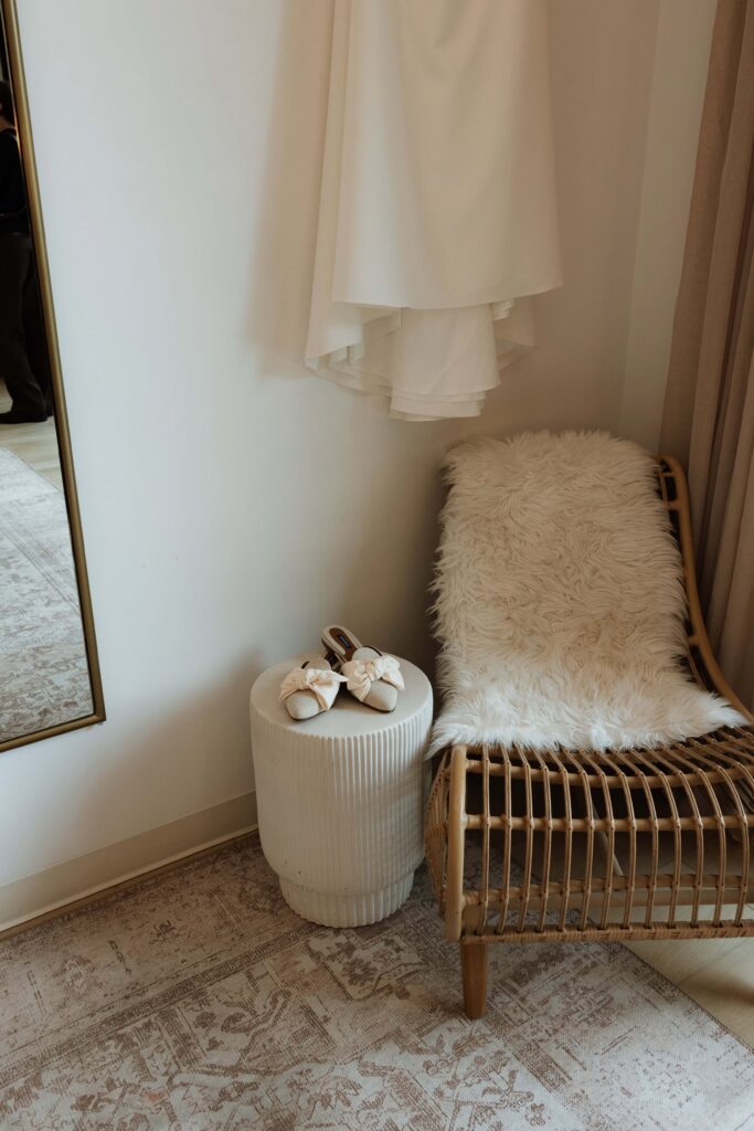 Wedding day details, bride's shoes, dress, and chair, in the getting ready suite at Catalyst.