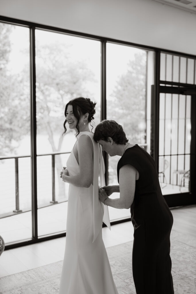 Mother of the bride helps zip up the brides dress in the getting ready suite at Catalyst by Nature Link.