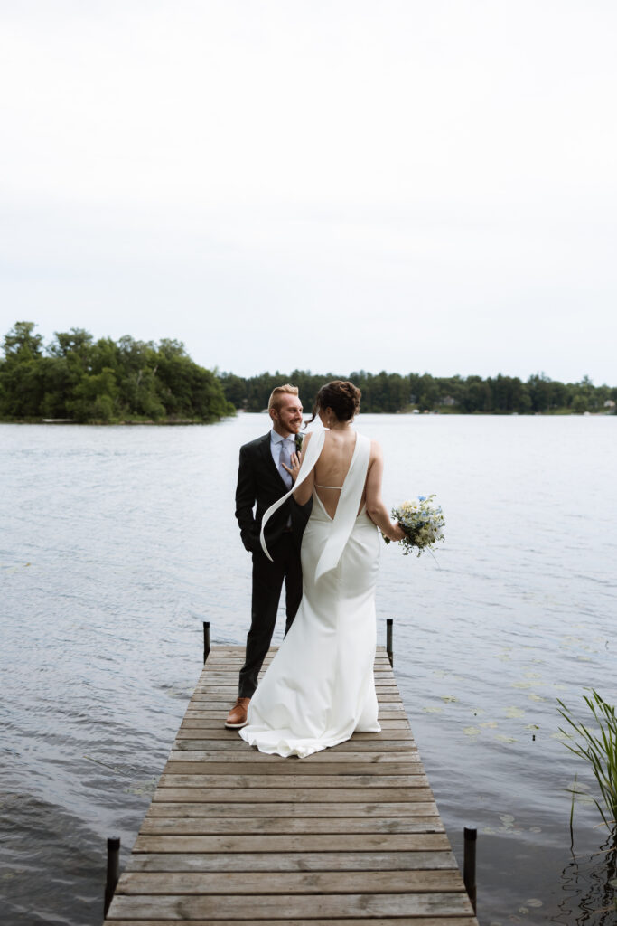 Bride faces the groom on the dock at Catalyst by Nature Link for their couple's portraits.
