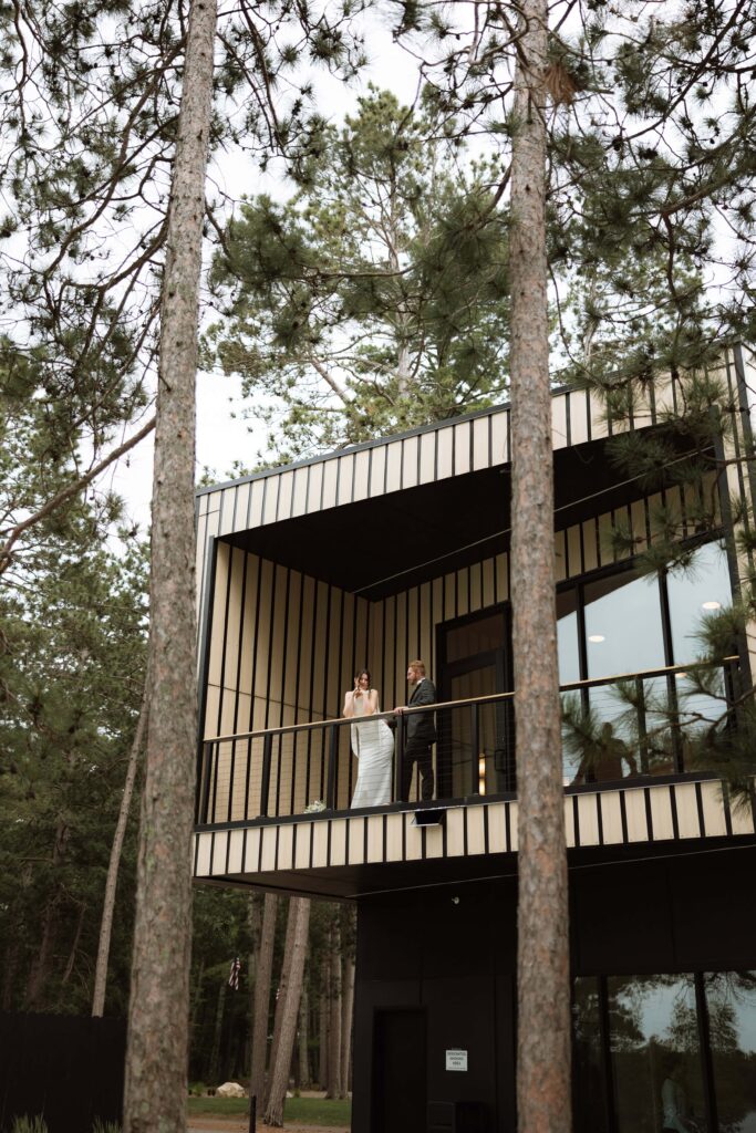 Bride and groom stand on the balcony at Catalyst by Nature Link.