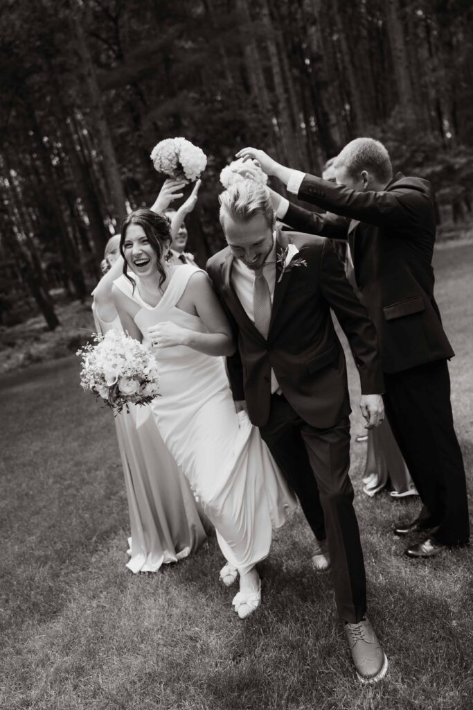 Bride and groom smiling and laughing with their wedding party in Nisswa, Minnesota.